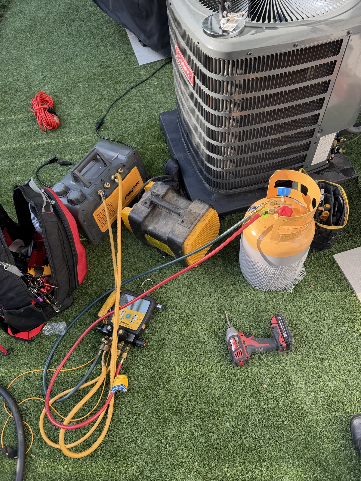 HVAC gauges and tools alongside an air conditioning unit