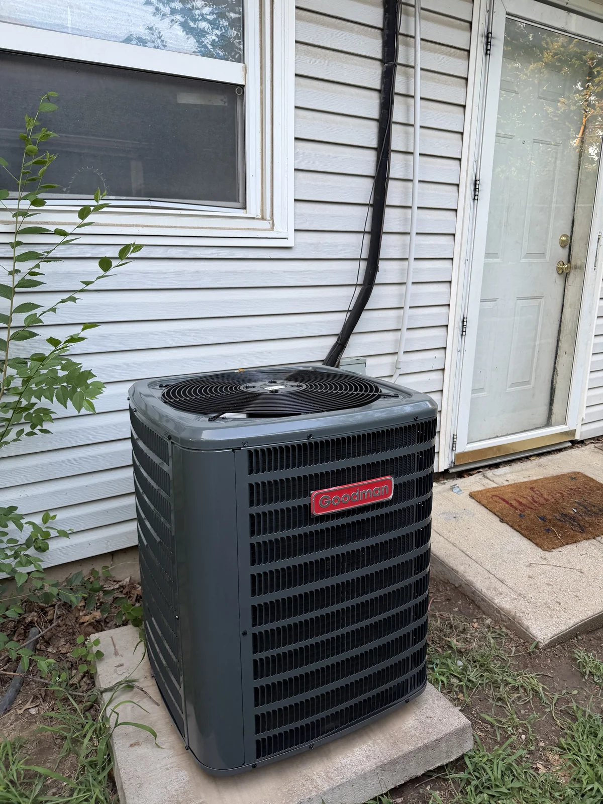 Goodman air conditioning installation beside a home